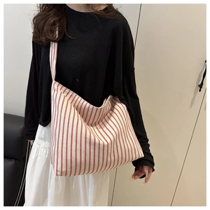 Détail du sac cabas en toile rayé rouge et blanc avec design spacieux et bandoulière