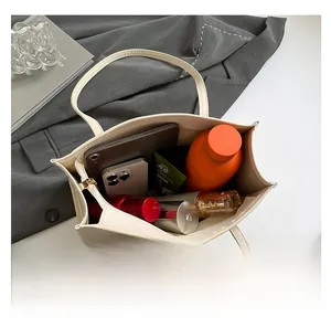 Internal view showing spacious capacity of the beige tote bag with daily essentials