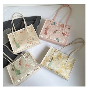 Close-up of four floral embroidery tote bags with elegant tassels and leather handles