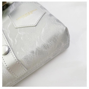 Close-up of silver leather square bag with wave texture and gold buckle detail