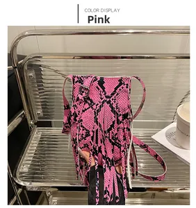 Detail of pink snake print crossbody bag with long fringe and silver metal buckle