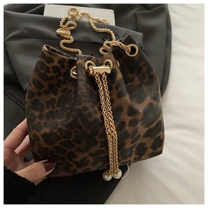 Close-up of leopard print bucket bag with gold chain and large pearl drawstring detail
