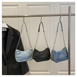 Close-up of three sequined denim crescent shoulder bags with chain straps in multiple colors