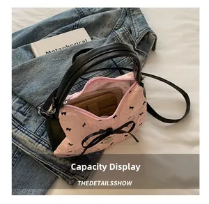 Vue de dessus du sac à nœuds roses montrant la capacité pour téléphone et portefeuille
