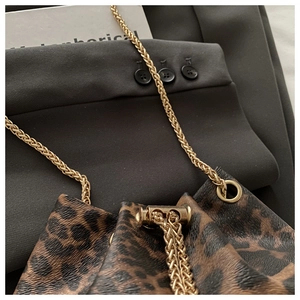 Detail of leopard print bucket bag with gold chain strap and drawstring closure system