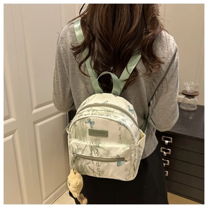 Detailansicht des Mini-Schmetterlings-Rucksacks mit Blumenmustern und modischem Lederetikett