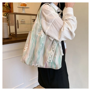 Détail de broderie sur sac fourre-tout en dentelle colorée avec motifs de fleurs