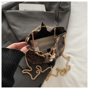 Top view of leopard print bucket bag interior showing daily essentials and golden chain