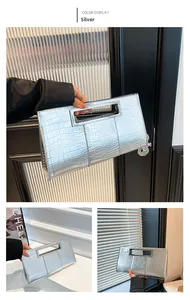 Detail of silver rectangle clutch bag with crocodile texture and integrated handle