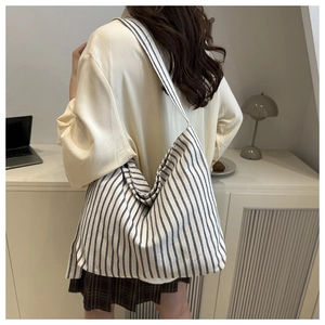 Detailed back view of a striped canvas tote bag in a minimalist office setting