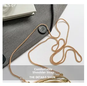 Detail of elegant gold woven metal chain strap with secure clasp for crossbody bag