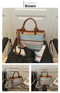 Detail der bunten Strohtasche mit braunen PU-Knotengriffen und Umhängegurt für den Sommer