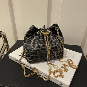 Detail of leopard print bucket bag with gold chain strap and elegant pearl drawstring