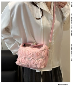 Detailed view of pink shoulder bag featuring 3D fabric rose floral appliques and metal clasp