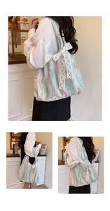 Détail du sac cabas avec nœud en dentelle blanche et broderie sur tissu à texture marbre