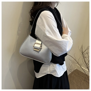 Silver metallic hobo shoulder bag featuring a prominent square buckle shown on model