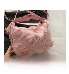 Close-up of pink shell bag with 3D mesh floral petals and golden metal buckle details