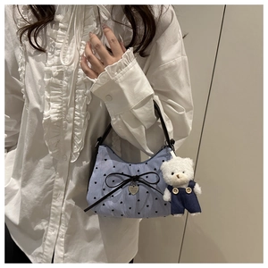 Détail du mini sac à main rayé bleu avec noeud noir et breloque peluche ours mignonne