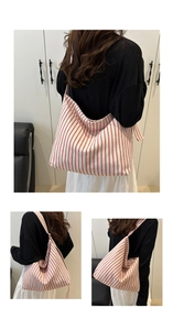 Détail d'un sac cabas en toile à rayures rouges avec de larges bandoulières et grande capacité