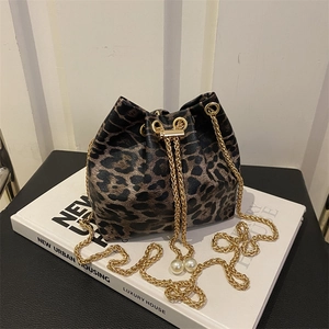 Detail of leopard print bucket bag with gold chain drawstring and pearl accents
