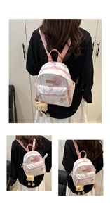 Detail of pink butterfly print backpack with cute teddy bear charm and fashion label