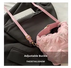 Detail of adjustable strap and golden buckle on pink floral crossbody handbag