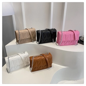 Detailed arrangement of quilted chain purses in five colors on geometric stands