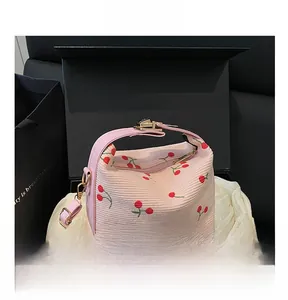 Detailed macro of pink corduroy fabric with cherry embroidery and gold metal lock