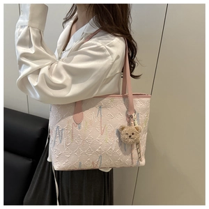 Detail der rosa gesteppten Shopper-Tasche mit Stickerei und Plüschbär-Anhänger