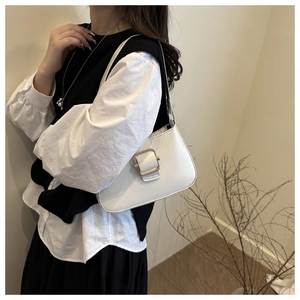 Detailed view of a white minimalist shoulder bag with a gold rectangular metal buckle
