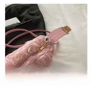 Close-up of pink 3D floral texture bag featuring a smooth gold metal zipper and strap