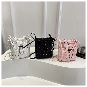 Quilted drawstring bucket bags in white, black and pink with bow embroidery details