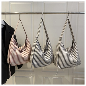 Detailed display of striped canvas tote bags in red, blue, and grey with adjustable straps