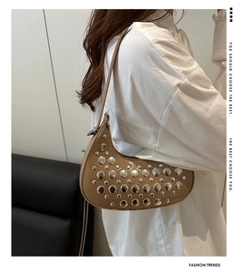 Detail of brown half-moon underarm bag with decorative silver rivets and sleek strap