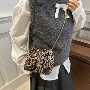 Detail of leopard print bucket bag with drawstring closure and elegant pearl accents