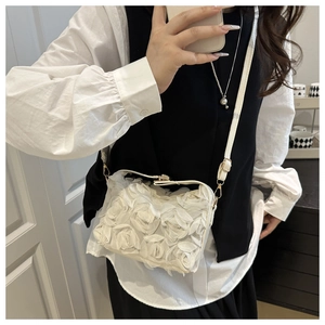 Détail des roses 3D en tissu blanc et de la texture en maille fine sur ce sac à bandoulière