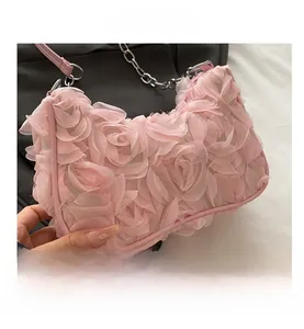 Close-up of pink 3D gauze rose petals on fashion evening bag with silver chain