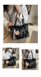 Detail of black tote bag with pink wave embroidery and a cute brown plush bear charm