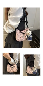 Détail du sac croissant rose matelassé avec nœud noir et pendentif ours mignon