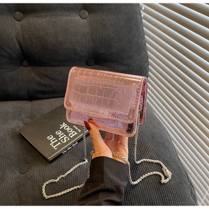Detailed view of pink croc-embossed patent leather mini bag with silver chain strap