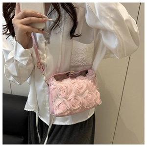 Détail du sac de soirée rose avec fleurs 3D en dentelle et chaîne dorée élégante