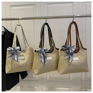 Three woven straw tote bags with patterned silk scarves in beige, black and brown trims