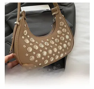 Close-up of khaki crescent bag featuring silver metal studs and premium PU leather texture