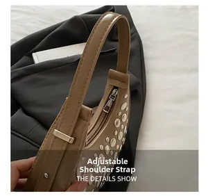 Close-up of silver metal rivets and adjustable shoulder strap on a khaki hobo bag