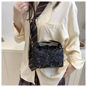 Détail du sac de soirée noir avec roses en tissu 3D et fermoir en métal doré élégant