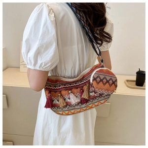 Détail d'un sac bandoulière tissé ethnique avec glands colorés et sangle à motifs variés