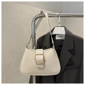 Chic cream white leather shoulder bag with gold square buckle on dark gray blazer background