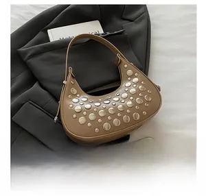 Detail view of khaki leather crescent underarm bag with silver rivets on grey suit