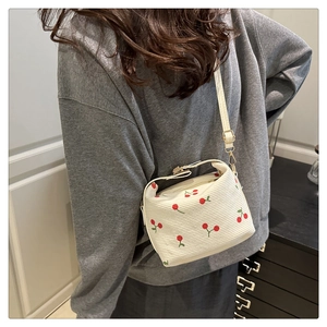 Detail view of white corduroy mini crossbody bag with sweet red cherry embroidery