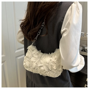 Close-up of white layered petal texture and silver chain strap on the crescent bag